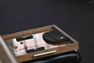 Military insignia and rank items are arranged on a wooden tray.
