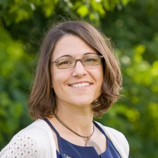 A woman smiling in an outdoor portrait.