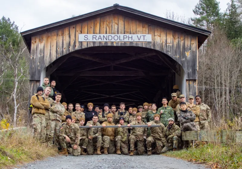Group of Norwich University Corps of Cadets posing in front of the S. Randolph, VT covered bridge.