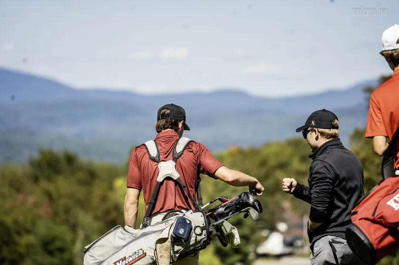 A shot from behind as cadet golfers walk the golf course.