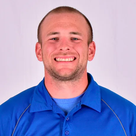 Person wearing a blue collared shirt over a blue T‑shirt.